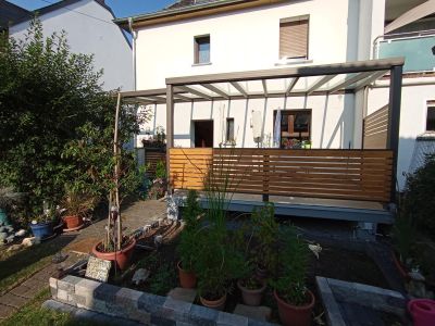 Terrassenüberdachung mit seitlichem Windschutz aus Holz