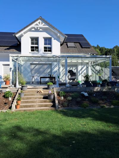 Sommergarten mit Glas-Schiebetüren entlang der Terrasse