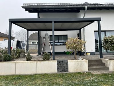 Terrassenüberdachung mit Glasfront und geschütztem Sitzplatz
