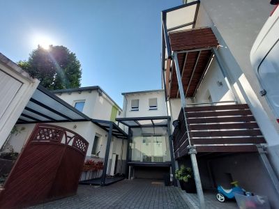 Terrassenüberdachung mit Glas-Schiebeelementen entlang der Front