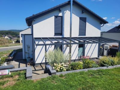 Terrassenüberdachung mit klarer Dacheindeckung und Pfosten