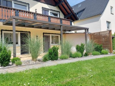 Überdachung mit klarer Glasfläche und modernem Hausanschluss