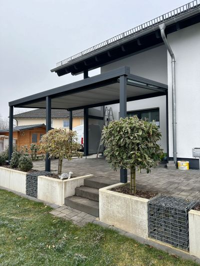 Terrassenüberdachung mit Glasdach, Markise und schlanken Pfosten