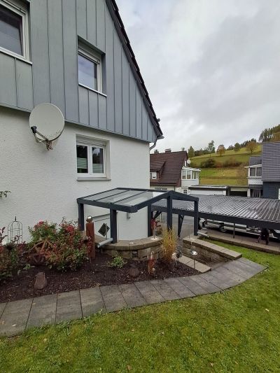 Terrassenüberdachung mit klarer Dacheindeckung und Regenrinne