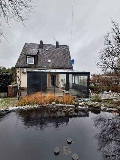 Verglaster Sommergarten-Anbau mit Blick auf einen teich