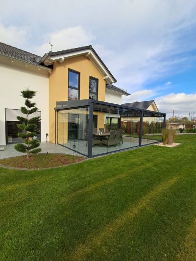 Sommergarten mit großen Glasflächen und Blick in den Garten