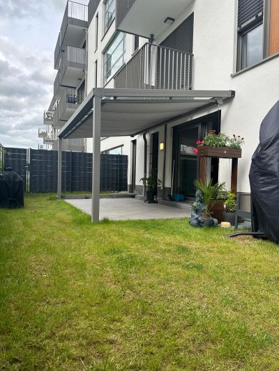 Terrasse mit Glasdach und ausgefahrener Unterglasmarkise