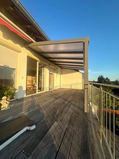 Glasüberdachung mit Markise als Sonnenschutz am Haus