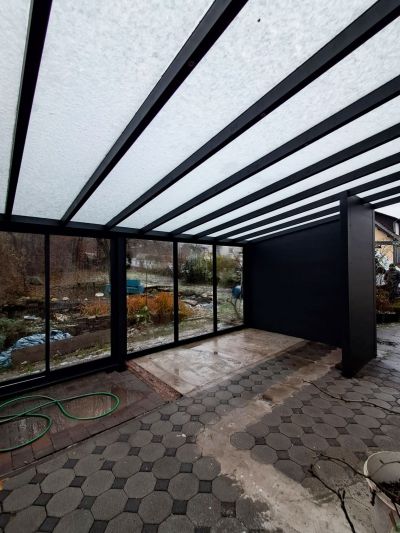 Sommergarten mit seitlichen Glaselementen als Wetterschutz