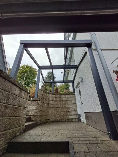 Terrassenüberdachung mit klarer Dacheindeckung am Wohnhaus