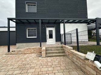 Terrassendach als Wetterschutz über Gartenterrasse